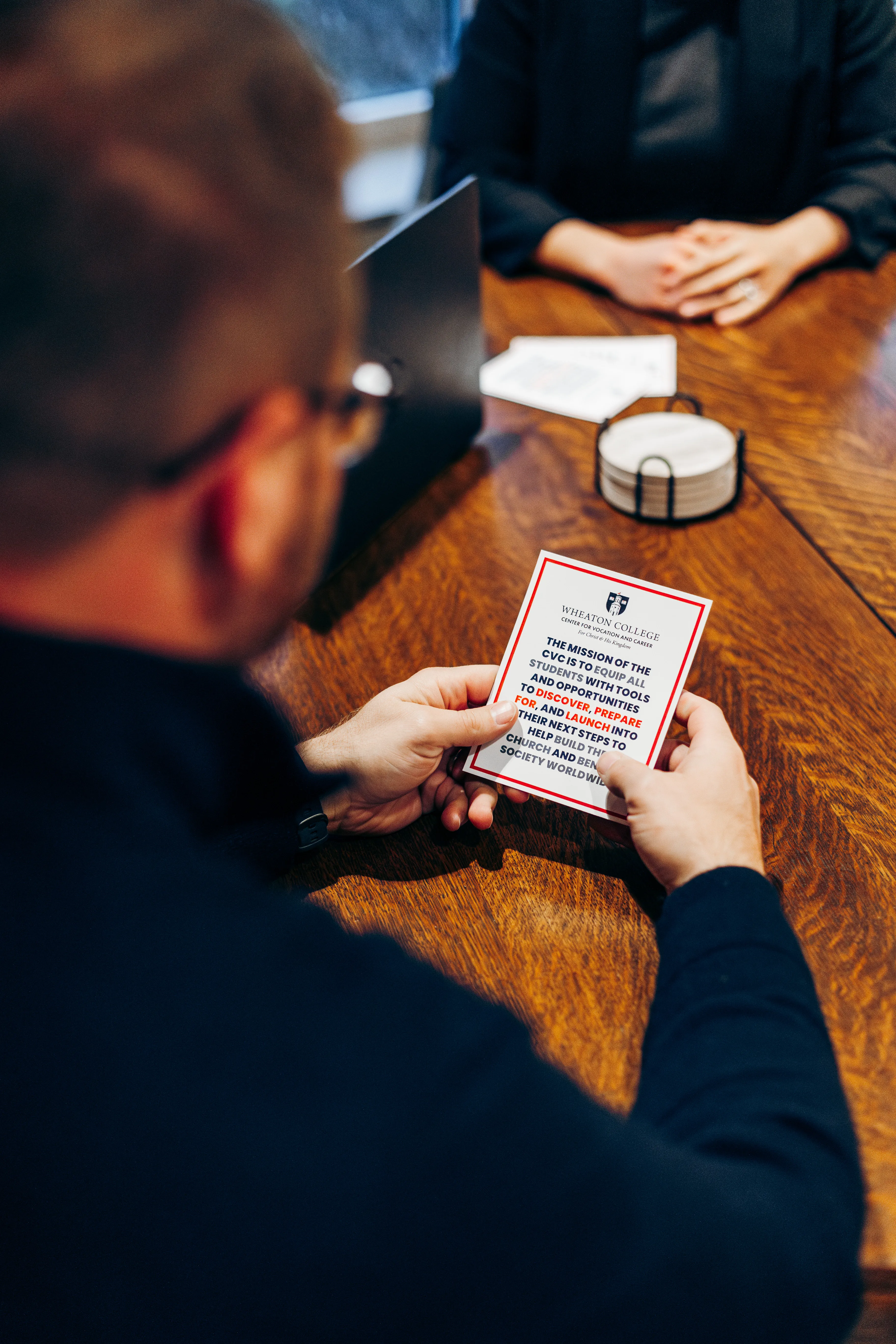 A man holding a card with the CVC mission statement