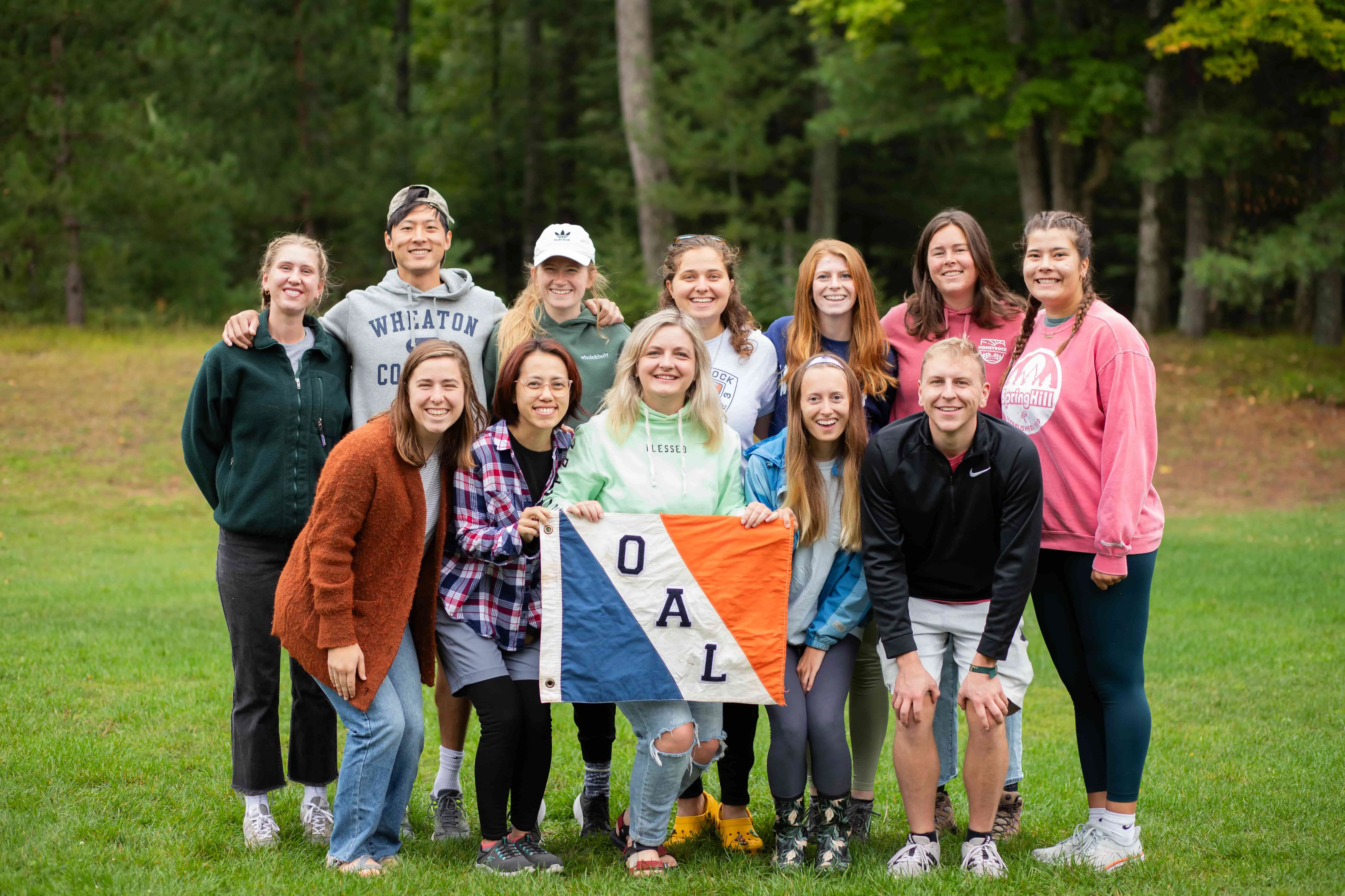 A group of students outside holding an OAL flag
