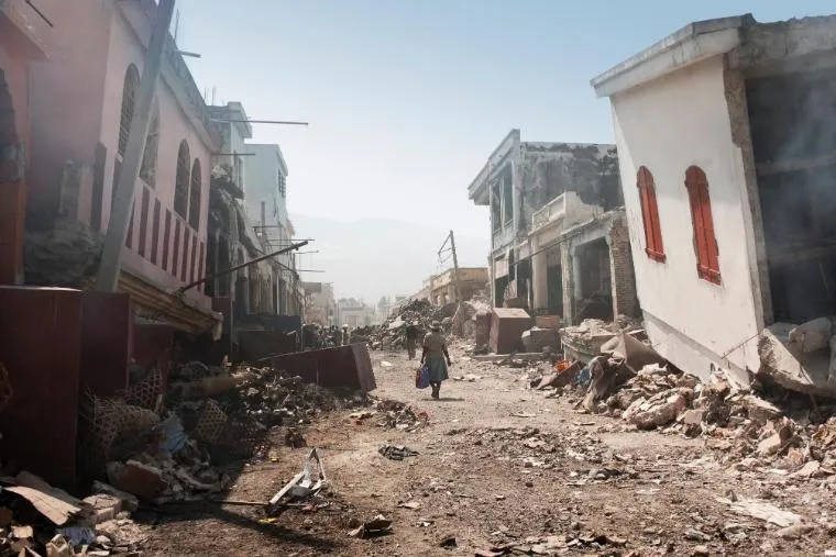 people walking through earthquake rubble