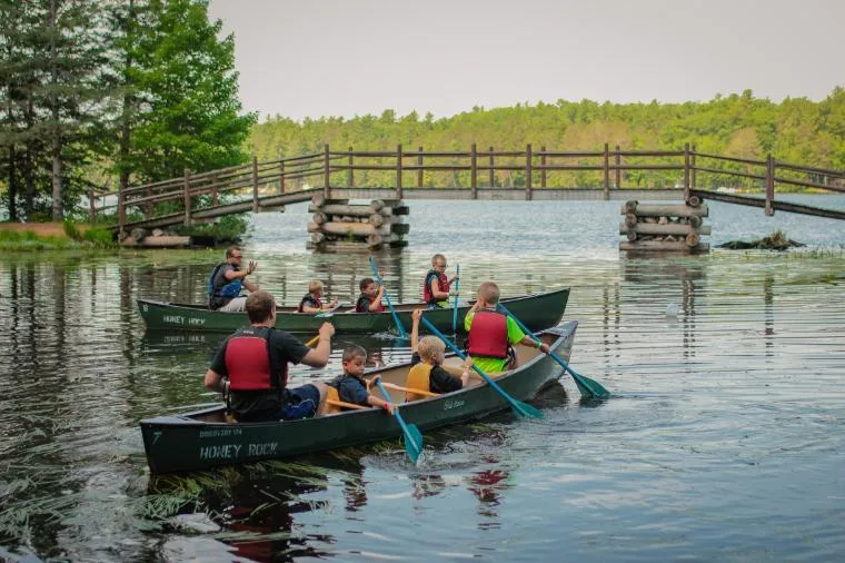 camper boys canoeing in lagoon onto long lake at honeyrock in three lakes wi