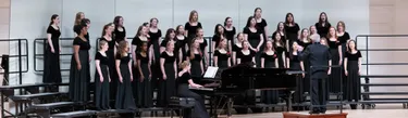 women standing and singing on stage