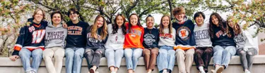 Students sitting on Wheaton sign