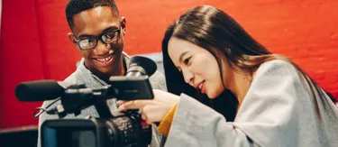 Comm Students looking through Camera 2025