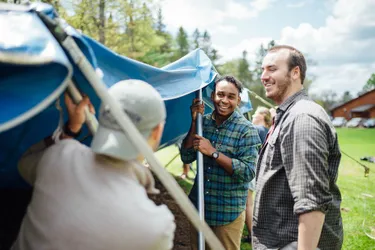 A group of young men putting up a tent