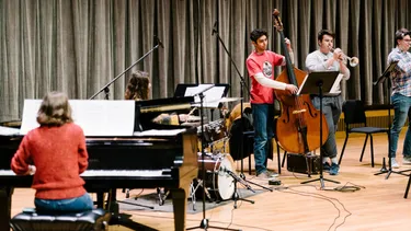Students practicing instruments on stage