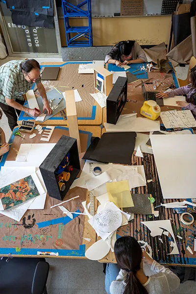 Professor and students working on an art project