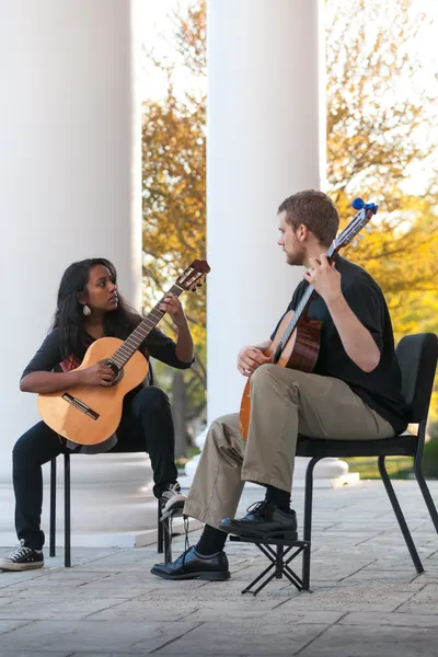Students playing guitar outside