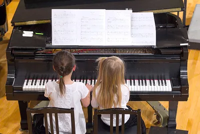 Two young girls playing piano duet