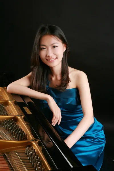 Professor Hyejin cho sitting next to a piano