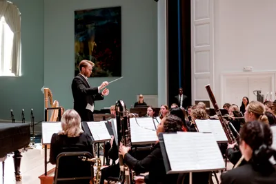 Students seated playing brass instruments