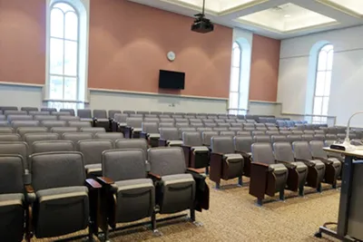 A room with a few rows of chairs