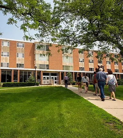 A group of people walking towards a building on campus