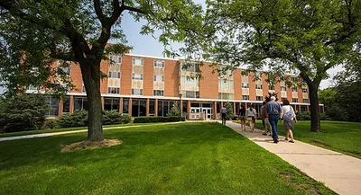 A group of people walking towards a building on campus