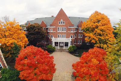 A building surrounded by trees with orange and yellow leaves
