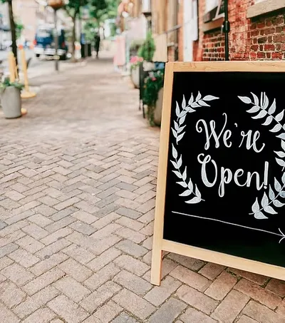 A sign on a street reads we are open