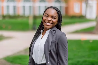 Azana Mack smiling at the camera in business formal.
