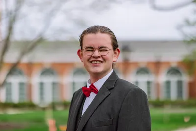 Josiah smiling at the camera in business attire.