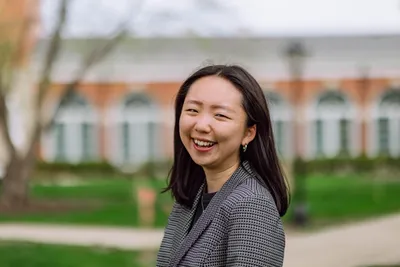 Sehee smiling at the camera in business attire.
