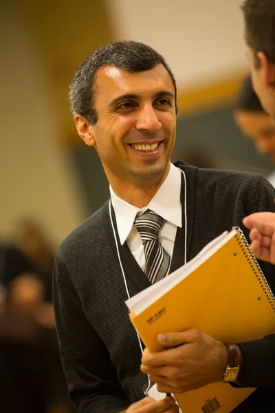 phd student at practicum seminar holding notebook and smiling