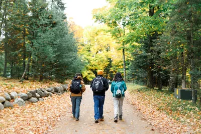 Three people with backpacks walking on a trail