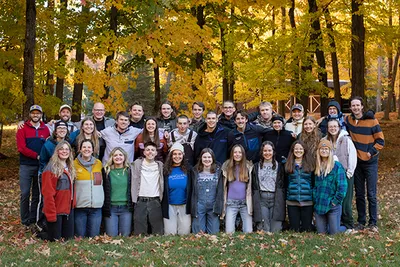 A group of people standing in front of trees