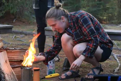 Olivia is lighting up a camp fire