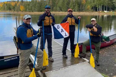 Four men holding a flag that says 