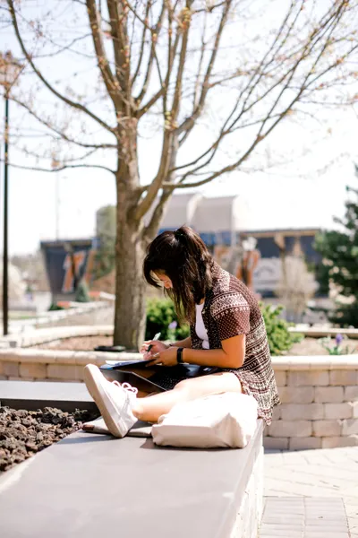 Wheaton College student reading outside in sunshine