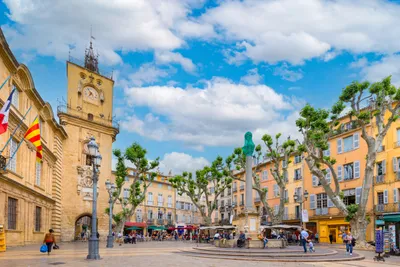 A town square with trees, buildings, and people