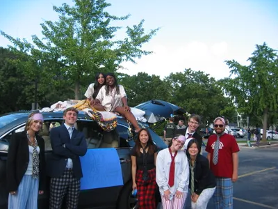 A group of student standing by a car