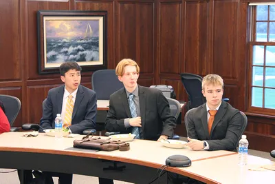 Three male student in a meeting dressing formally