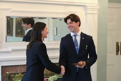 Two students shaking hands and smiling