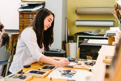 Student doing letter press at Wheaton College IL Art Department Adams Hall