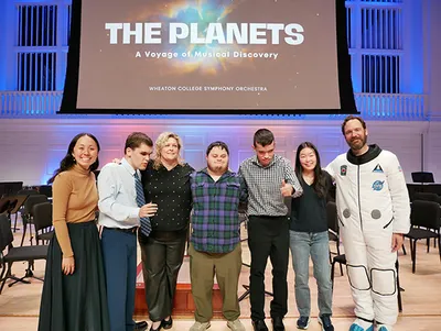 Several people taking a group photo on a stage
