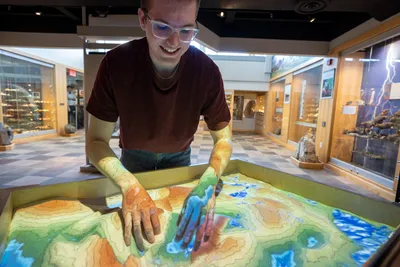 Wheaton Student with hands on topographical  map