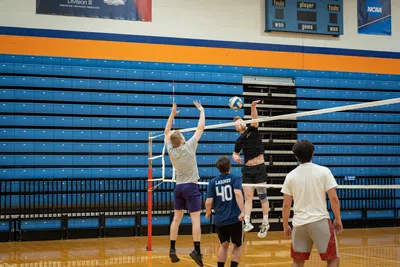 A student spikes over the net in an intramural volleyball game in King Arena.