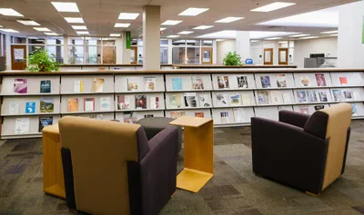 Magazines on library shelves and chairs.