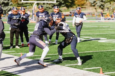 Two football players in a drill during practice at McCully Stadium.