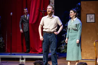 Three students performing on stage in the opera.
