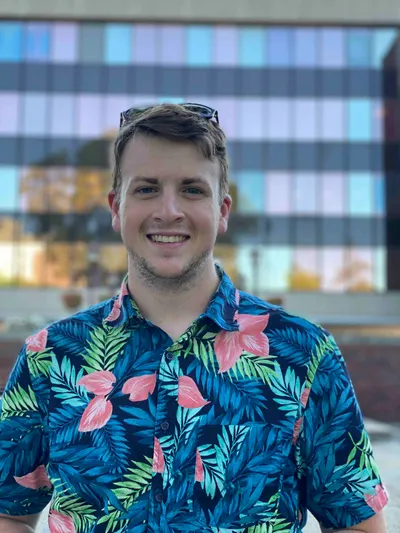 a student smiling at the camera in a colorful shirt