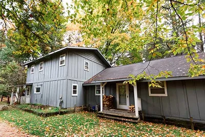 A gray house in a wooded yard
