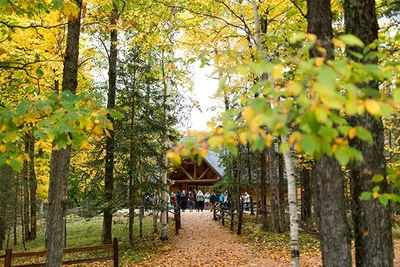 People standing in front of a house in the woods