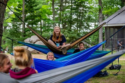 A few girls sitting in hammocks under trees