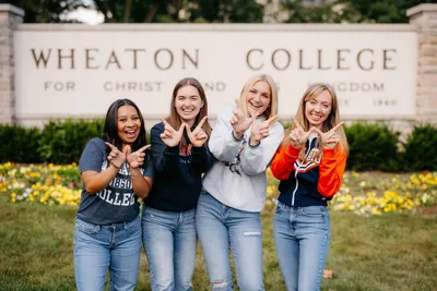 Four Wheaton College IL Students in Front of Main Campus Sign