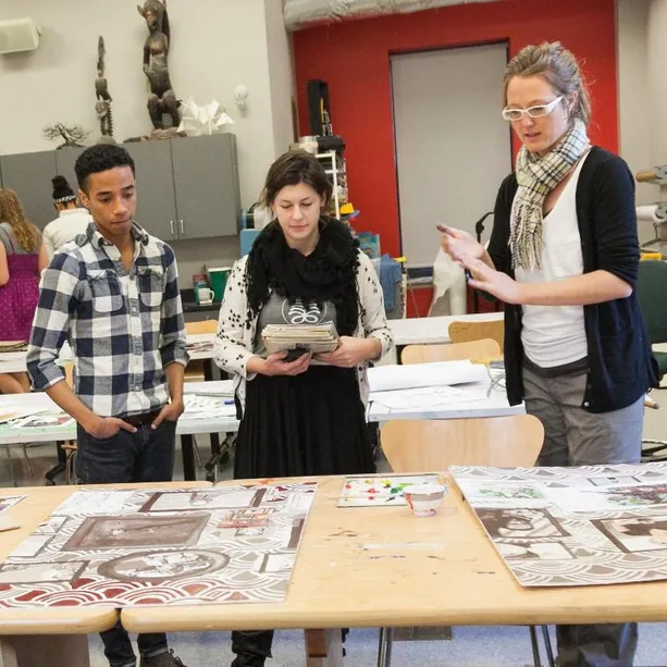 A teacher teaching two students in a class