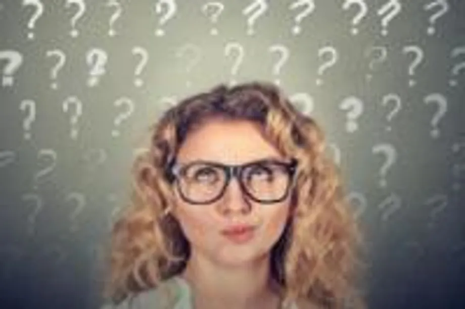woman wearing glasses surrounded by question marks