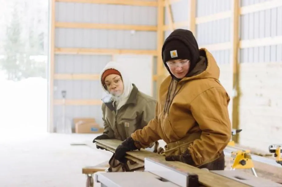 vanguard women cutting down wood board
