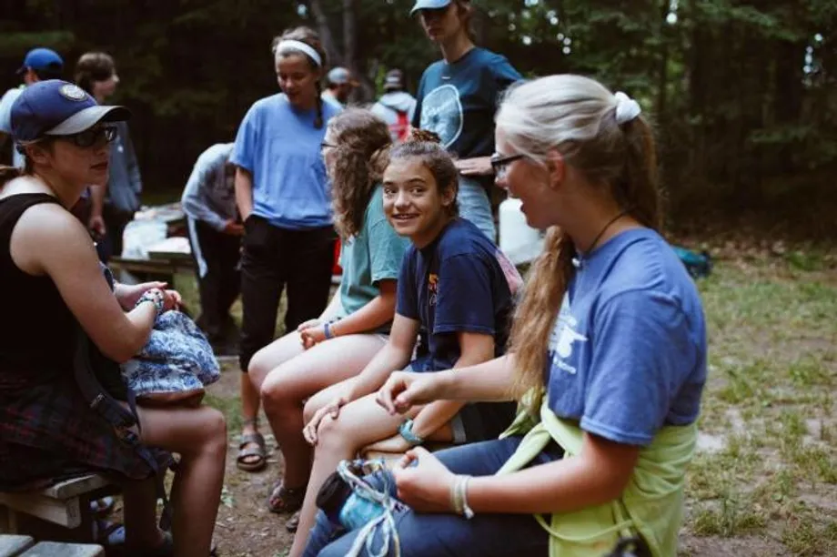 high school campers talking around a fire