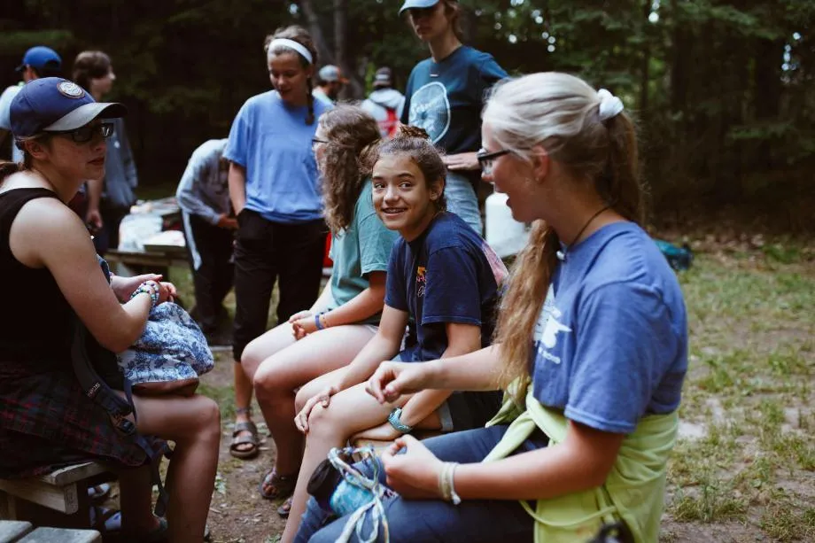 high school campers talking around a fire