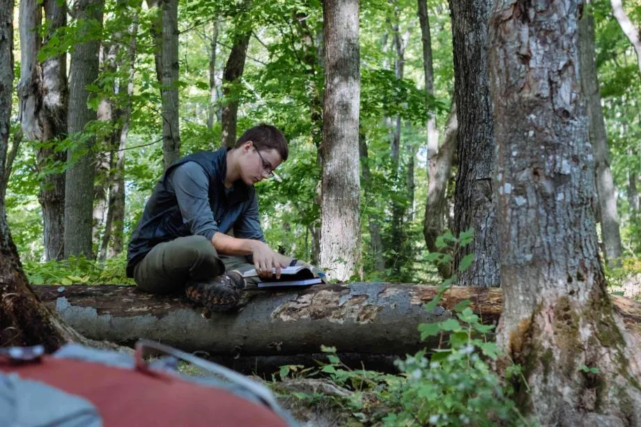 jacob estep journaling on a log